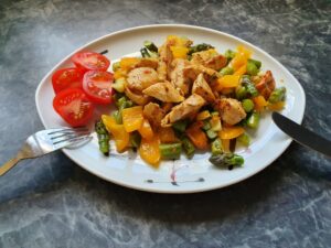 Antiaging with healthy food! Here fried vegetables with chicken strips and fresh tomato